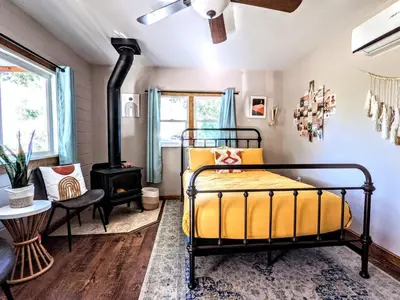 a bedroom with a bed and a stove at The Bluebird's Nest - Cabin with Fireplace in Santa Ysabel
