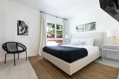 a white bedroom with a bed and a chair at Avalon 2 Unit Buyout II IV by AvantStay Mins to Gaslamp Patio w BQQ in San Diego