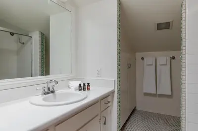 a white bathroom with a sink and a mirror at Bay View I by AvantStay Stylish Mission Beach Home on the Sand in San Diego