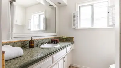 a bathroom with a sink and a mirror at Bay View I by AvantStay Stylish Mission Beach Home on the Sand in San Diego