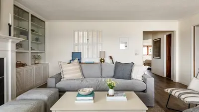 a living room with a couch and a table at Bay View I by AvantStay Stylish Mission Beach Home on the Sand in San Diego