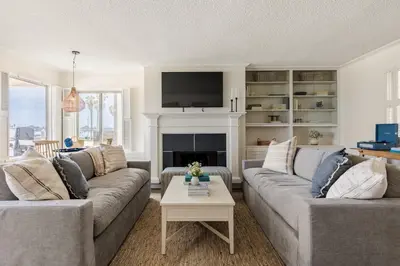 a living room with two couches and a fireplace at Bay View I by AvantStay Stylish Mission Beach Home on the Sand in San Diego