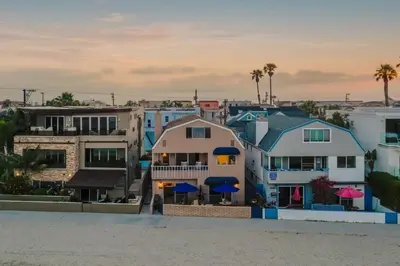 a group of buildings with blue umbrellas in a city at Bay View 3 by AvantStay Stunning Home on the Beach In Mission Beach in San Diego