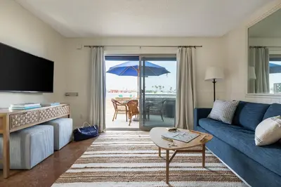 a living room with a couch and a table with an umbrella at Bay View 3 by AvantStay Stunning Home on the Beach In Mission Beach in San Diego