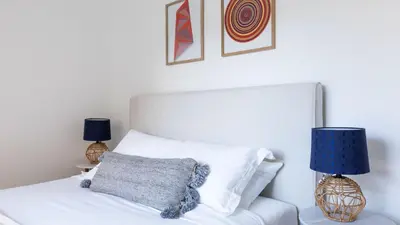 a bedroom with a white bed with two lamps at Avalon 2 Unit Buyout I III AvantStay Mins to GaslampBeautiful Deck w BBQ in San Diego