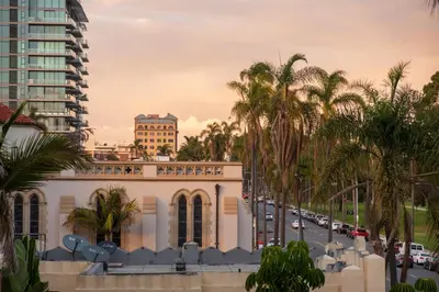 a building with palm trees in front of a street at Balboa I by AvantStay - Stylish Condo Balboa Park Adjacent w Views in San Diego
