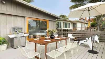a patio with a table and chairs and an umbrella at Camden by AvantStay 5mins to the Beach Elevated Home w Pacific Ocean Views in Encinitas