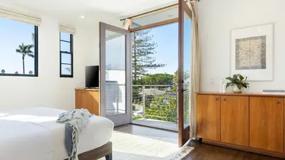 a bedroom with a bed and a sliding glass door at Vista Del Mar by AvantStay Stunning Spanish Inspired Home w Pool Hot Tub Rooftop Patio in San Diego