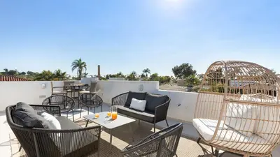 a patio with chairs and tables on a roof at Vista Del Mar by AvantStay Stunning Spanish Inspired Home w Pool Hot Tub Rooftop Patio in San Diego
