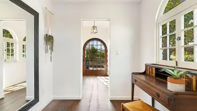a hallway with a mirror and a table with a plant on it at Vista Del Mar by AvantStay Stunning Spanish Inspired Home w Pool Hot Tub Rooftop Patio in San Diego