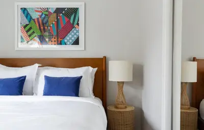 a bedroom with a white bed with blue pillows at Hamilton I by AvantStay Beach House Rooftop Deck Newly Renovated Bungalow in San Diego