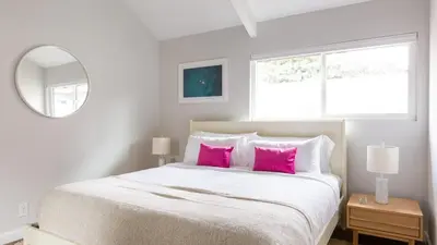 a bedroom with a large bed with pink pillows at Hamilton I by AvantStay Beach House Rooftop Deck Newly Renovated Bungalow in San Diego