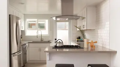 a white kitchen with a stove and a refrigerator at 3 Blocks to Beach Private Pool Rooftop Patio Hamilton I II by AvantStay in San Diego
