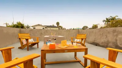 a patio with wooden chairs and a table with candles at 3 Blocks to Beach Private Pool Rooftop Patio Hamilton I II by AvantStay in San Diego