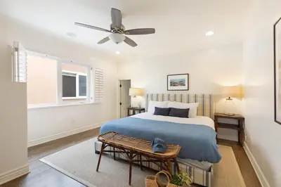 a bedroom with a bed and a ceiling fan at Shoreline by AvantStay Spectacular Beachfront Home w Fire Pit Spa Pool Table in San Diego