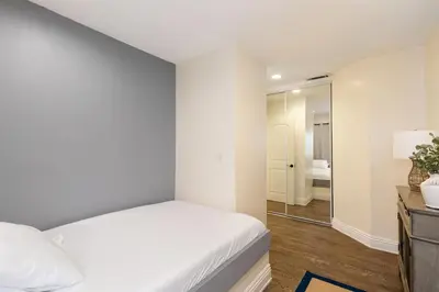 a bedroom with a white bed and a mirror at Shoreline by AvantStay Spectacular Beachfront Home w Fire Pit Spa Pool Table in San Diego
