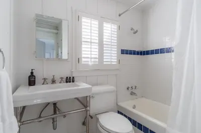 a white bathroom with a sink and a toilet and a tub at Topaz By AvantStay Adorable Cottage Walking Distance to Beach w Large Patio in San Diego