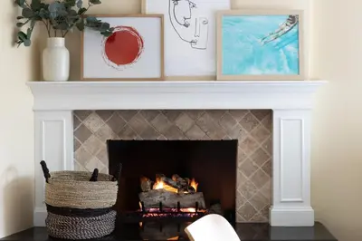 a fireplace with a white mantel with two framed pictures at Oliver by AvantStay Summer Escape Beach House 4 Blcks from Ocean in San Diego