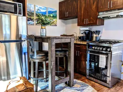 a kitchen with a counter with a stove and a refrigerator at #6 The Hawks Hideout Cabin in Santa Ysabel