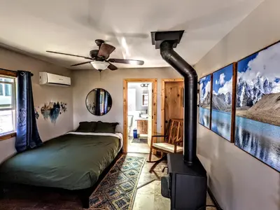 a bedroom with a bed and a wood stove at Falcon's Chalet- Cabin in Santa Ysabel