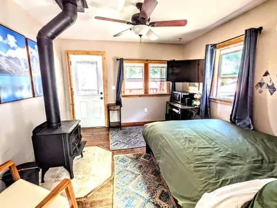 a bedroom with a wood stove and a bed at Falcon's Chalet- Cabin in Santa Ysabel