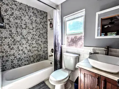 a bathroom with a toilet and a tub and a sink at Falcon's Chalet- Cabin in Santa Ysabel