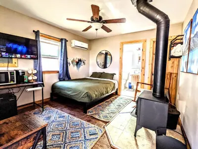 a bedroom with a wood stove in a room at Falcon's Chalet- Cabin in Santa Ysabel