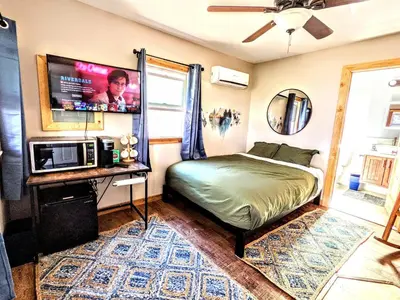 a bedroom with a bed and a flat screen tv at Falcon's Chalet- Cabin in Santa Ysabel