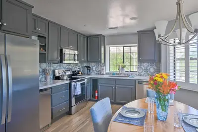 a kitchen with blue cabinets and a table with flowers on it at Hilltop Hideaway in Temecula Wine Country in Sage