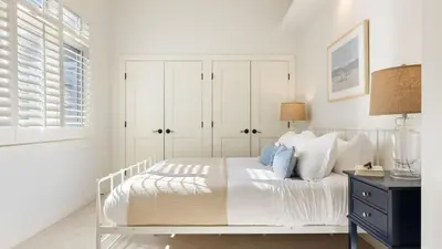 a white bedroom with a white bed and a window at Crystal Cove by AvantStay Gorgeous Charming Newport Home in Newport Beach