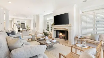 a living room with a couch and a fireplace at Crystal Cove by AvantStay Gorgeous Charming Newport Home in Newport Beach