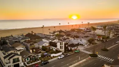 an aerial view of a town with a beach and the sunset at Sand Castle by AvantStay Beach House on Balboa Peninsula w Patio Hot Tub in Newport Beach