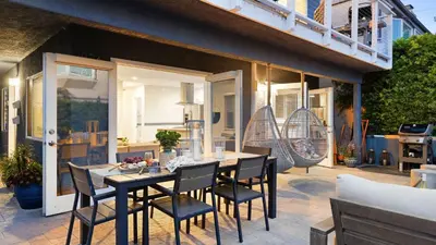 a patio with a table and chairs and a balcony at Mission Point Buyout by AvantStay Two Unit Buyout w Patio Fire Pit Close to Beach 6BDRs in San Diego