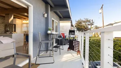 a balcony with a table and chairs on a house at Mission Point 2 by AvantStay Mission Beach Home w Large Balcony Steps to Beach in San Diego