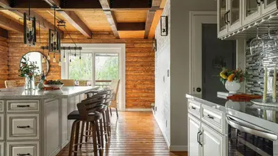 a kitchen with white cabinets and a bar with stools at Chateau Syrah by AvantStay Picturesque Estate w Pool Hot Tub Table Tennis Pool Table New Pickleball Court Basketball hoop in Temecula