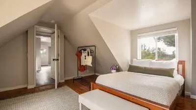 a attic bedroom with a bed and a window at Chateau Syrah by AvantStay Picturesque Estate w Pool Hot Tub Table Tennis Pool Table New Pickleball Court Basketball hoop in Temecula