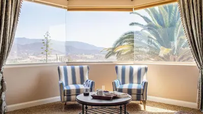 two chairs and a table in front of a large window at Sangiovese By AvantStay Spectacular Estate w Pool Hot Tub Putting Green in Temecula