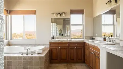 a bathroom with two sinks and a tub and a mirror at Sangiovese By AvantStay Spectacular Estate w Pool Hot Tub Putting Green in Temecula
