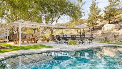 a patio with a table and chairs next to a pool at The Riesling Retreat by AvantStay Estate w Pool HotTub Putting Green Pickle Ball Court in Sage