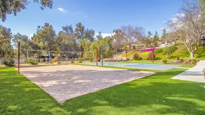a tennis court with a net in a park at The Riesling Retreat by AvantStay Estate w Pool HotTub Putting Green Pickle Ball Court in Sage