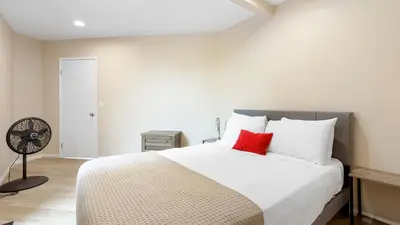 a bedroom with a large white bed with red pillows at Beachfront Home w Ocean Views • Right on Mission Beach Belmont by AvantStay in San Diego