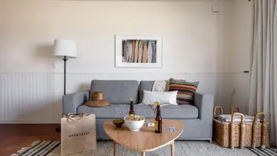 a living room with a blue couch and a table at Bay View II by AvantStay Ocean View Mission Beach Home on the Sand in San Diego