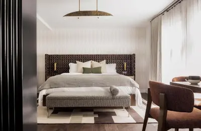a bedroom with a large bed and a chair at Orli La Jolla in San Diego