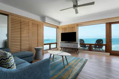 a living room with a blue couch and a television at Pier South Resort, Autograph Collection in Imperial Beach