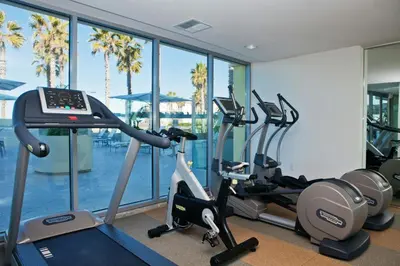 a gym with two treadmills and cardio machines at Pier South Resort, Autograph Collection in Imperial Beach