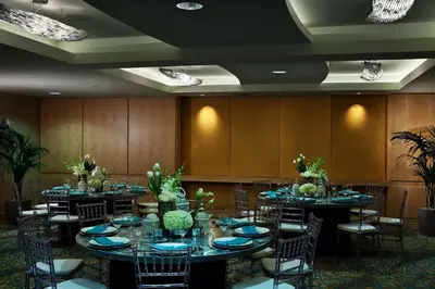a conference room with tables and chairs with plants at Pier South Resort, Autograph Collection in Imperial Beach