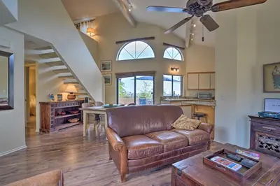 a living room with a leather couch and a table at Borrego Springs Retreat with Grill and Patio! in Borrego Springs