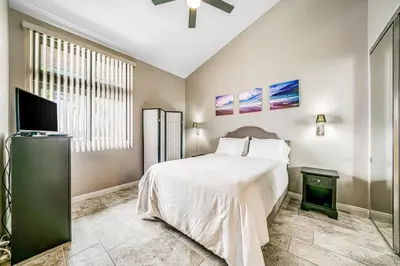 a bedroom with a bed and a flat screen tv at Whitewater Village Charm in Oceanside
