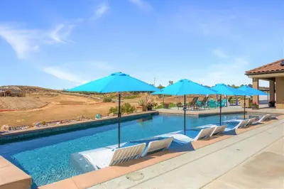 a swimming pool with chairs and umbrellas at Gaia Inn & Spa- Adult Only- Temecula Wine Country in Temecula