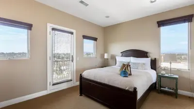 a bedroom with a bed and two windows at Palazzo Del Sol By AvantStay Breathtaking Home w Mountain Views Hot Tub in Temecula